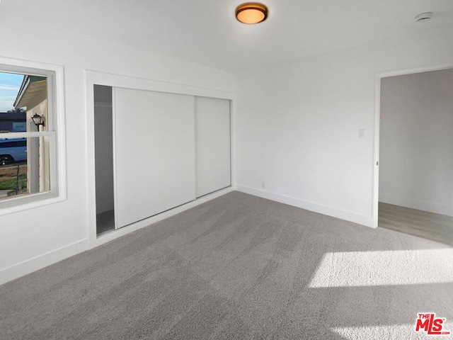 unfurnished bedroom with carpet flooring and a closet