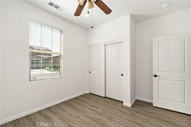 unfurnished bedroom featuring a closet, ceiling fan, and hardwood / wood-style flooring