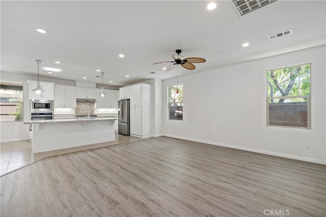 kitchen with white cabinetry, a healthy amount of sunlight, and stainless steel appliances