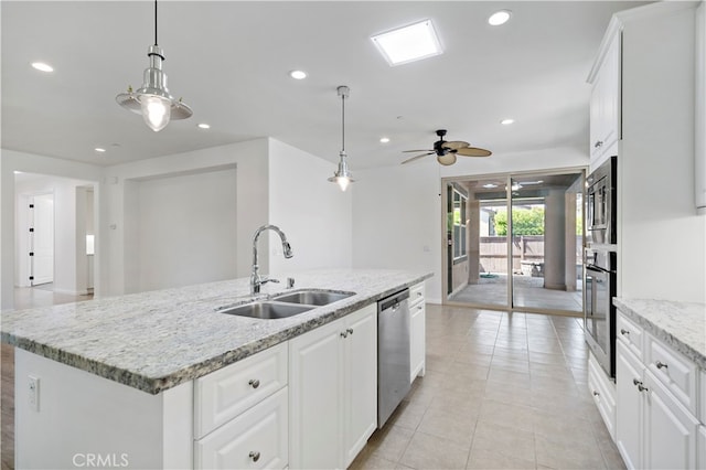 kitchen with white cabinets, stainless steel appliances, a center island with sink, and sink