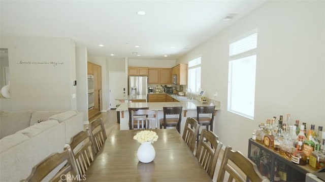 dining space featuring sink and light wood-type flooring