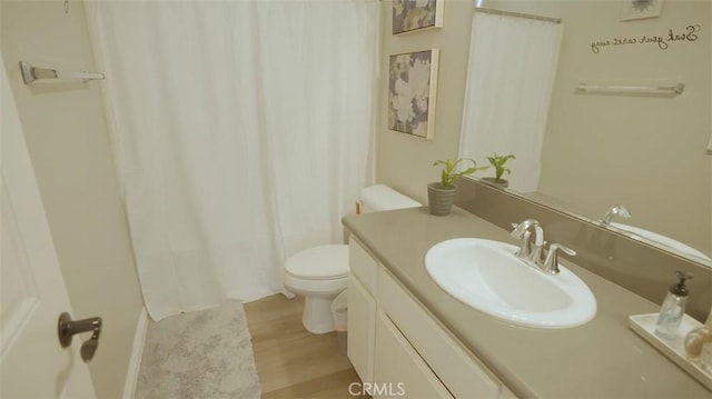 bathroom featuring toilet, vanity, and hardwood / wood-style flooring