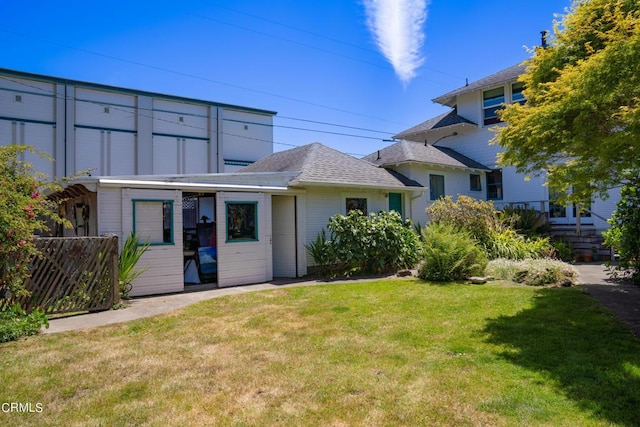 rear view of property featuring a lawn