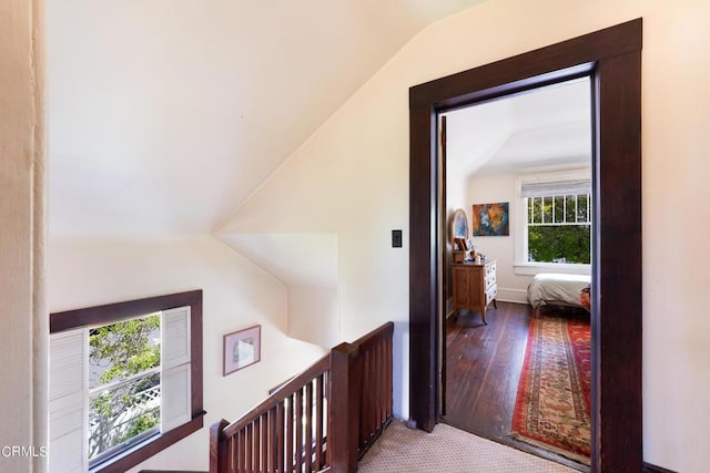 hall with vaulted ceiling and hardwood / wood-style flooring