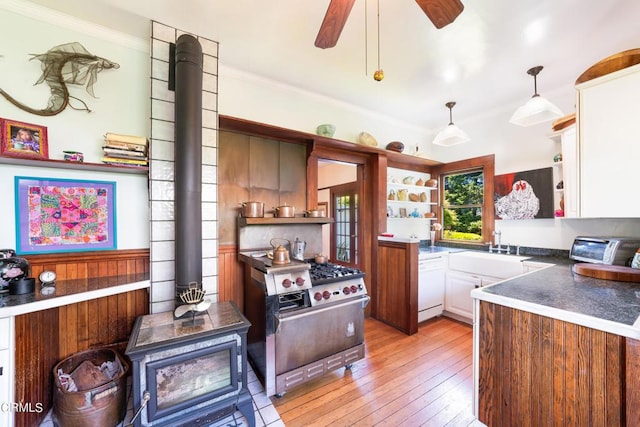 kitchen featuring white dishwasher, high end stainless steel range, ceiling fan, light wood-type flooring, and decorative light fixtures