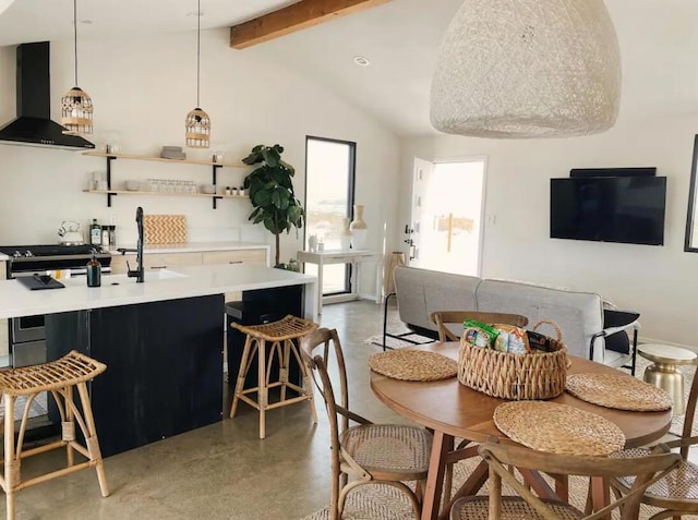 dining room with concrete floors and vaulted ceiling with beams