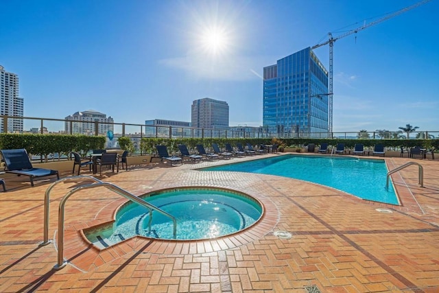 view of swimming pool with a patio and a hot tub