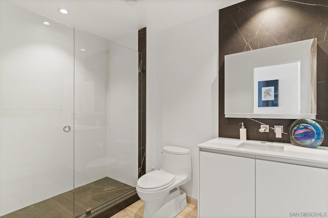 bathroom with vanity, toilet, and tiled shower