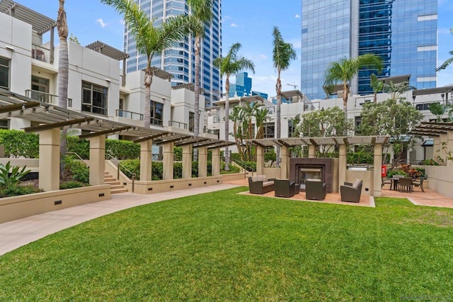 view of property's community featuring outdoor lounge area, a pergola, and a lawn