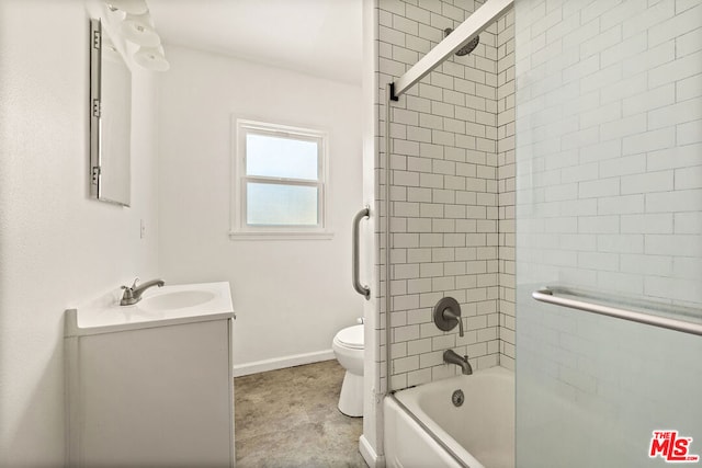 full bathroom featuring tiled shower / bath, vanity, and toilet