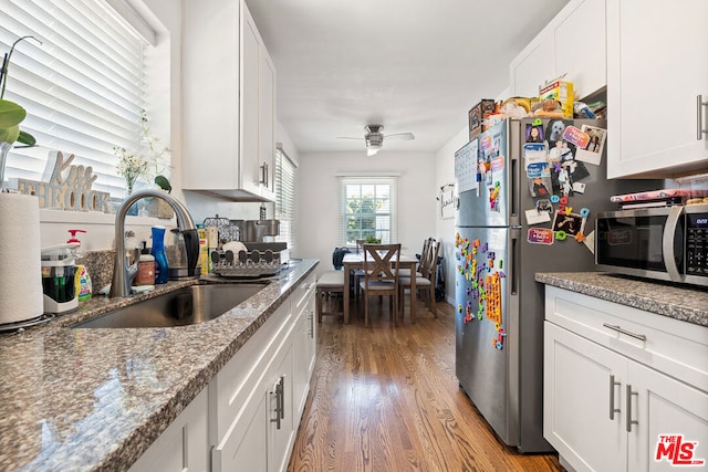 kitchen featuring light hardwood / wood-style floors, ceiling fan, sink, stainless steel appliances, and white cabinetry