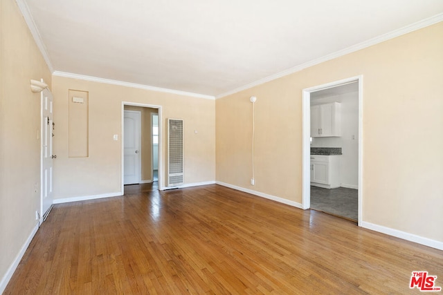 unfurnished room featuring ornamental molding and light hardwood / wood-style floors