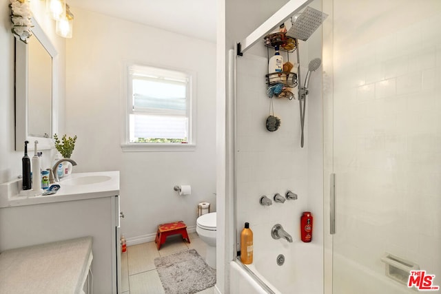 full bathroom featuring vanity, tile patterned flooring, toilet, and combined bath / shower with glass door