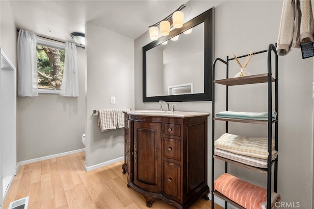 bathroom featuring vanity, toilet, and hardwood / wood-style flooring