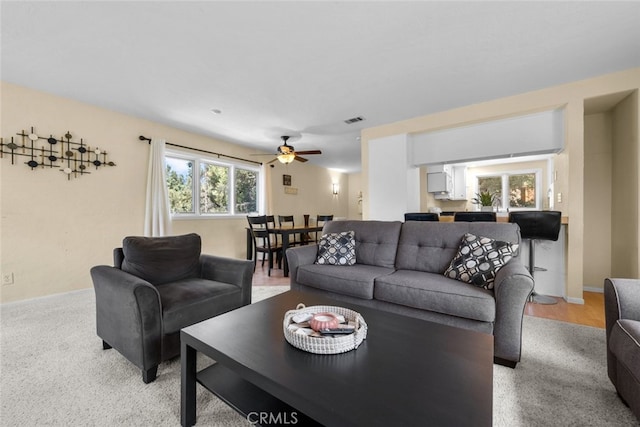 carpeted living room with ceiling fan