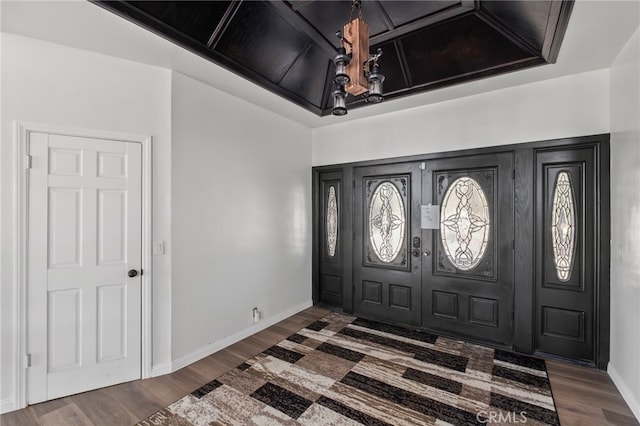 foyer entrance featuring dark wood-type flooring and an inviting chandelier