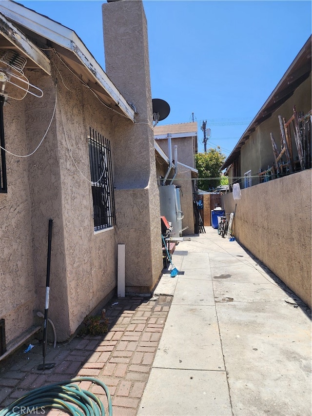 view of property exterior featuring a patio area and gas water heater