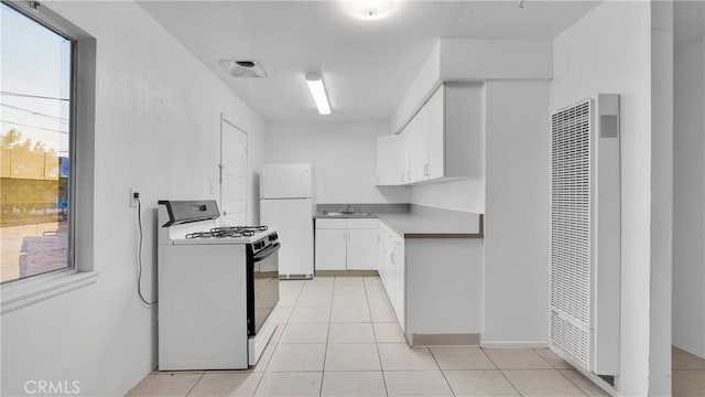 kitchen featuring light tile patterned flooring, white appliances, sink, and white cabinets