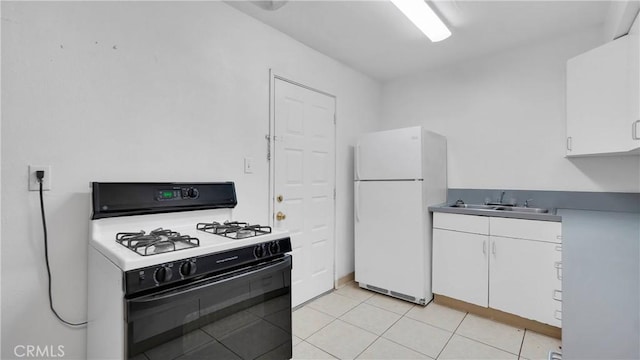 kitchen with white fridge, white cabinetry, sink, and range with gas cooktop