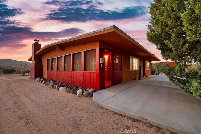 property exterior at dusk with a mountain view