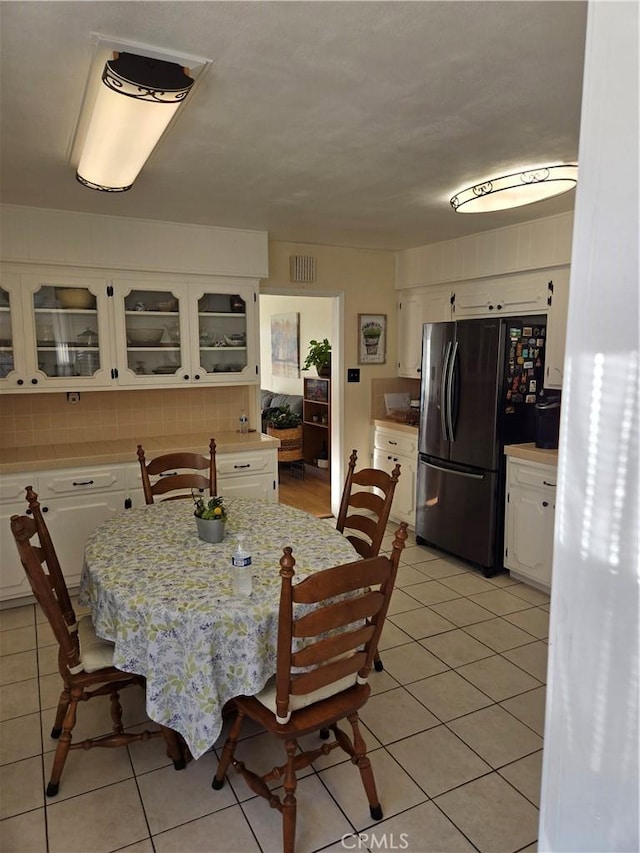 dining area featuring light tile patterned flooring and visible vents