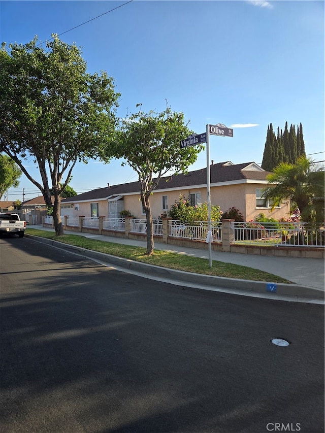 view of front of house with a fenced front yard, a residential view, and stucco siding