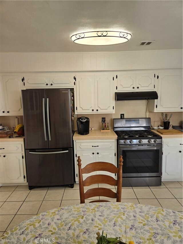 kitchen featuring under cabinet range hood, visible vents, white cabinets, and appliances with stainless steel finishes