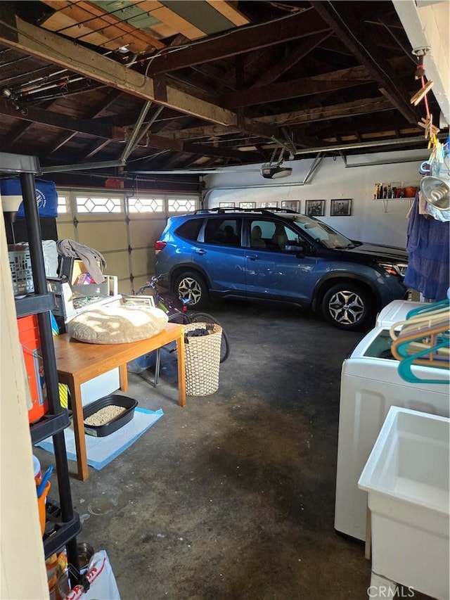 garage featuring washer / dryer, a garage door opener, and a sink