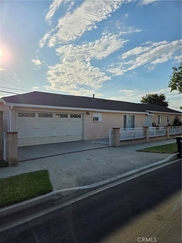 single story home featuring stucco siding, a garage, a fenced front yard, and driveway