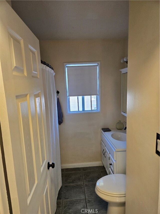 bathroom with vanity, baseboards, curtained shower, tile patterned floors, and toilet