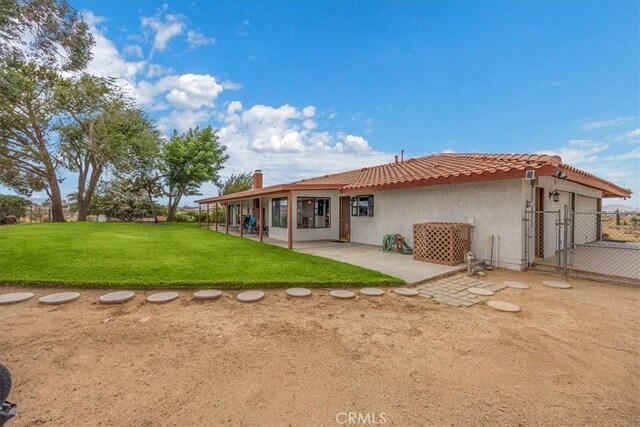 rear view of house featuring a yard and a patio