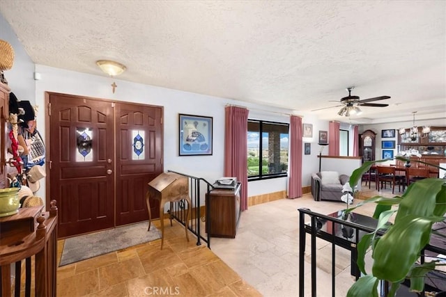 entrance foyer featuring ceiling fan and a textured ceiling