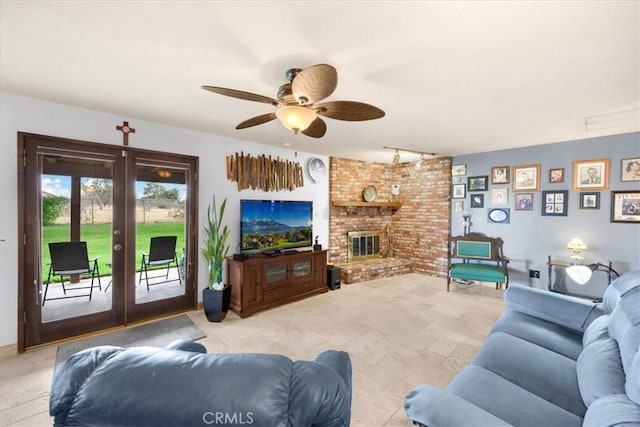 living room featuring french doors, rail lighting, a brick fireplace, and ceiling fan