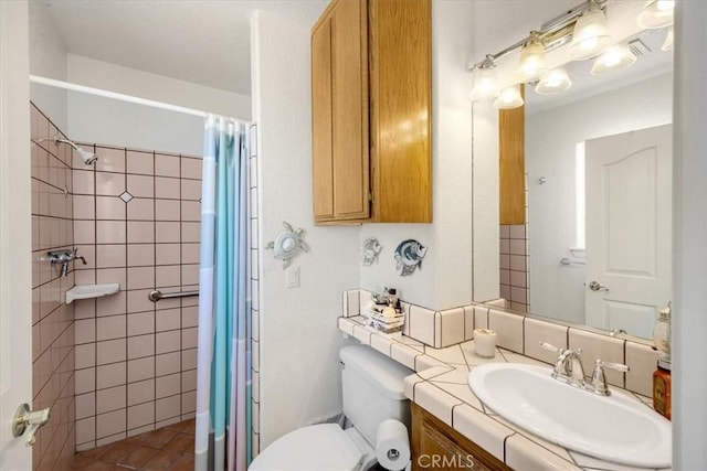 bathroom featuring tile patterned flooring, toilet, vanity, and walk in shower