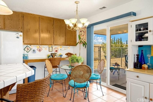 dining space with a notable chandelier and light tile patterned flooring