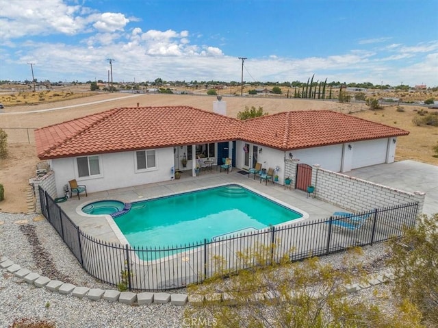 view of pool featuring a patio area and an in ground hot tub