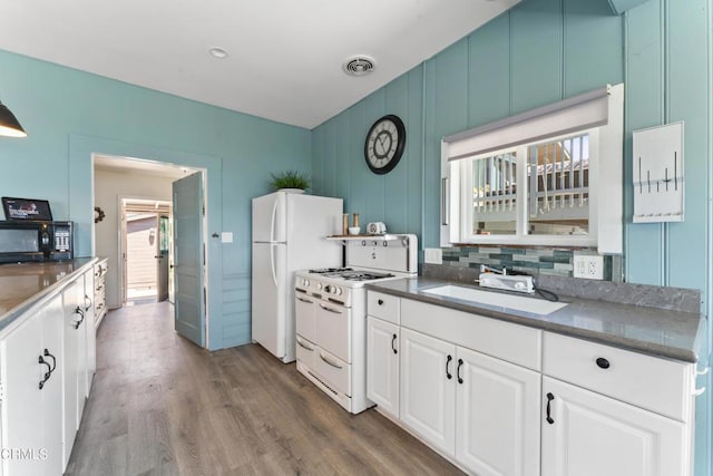 kitchen featuring decorative backsplash, white appliances, sink, wood-type flooring, and white cabinetry