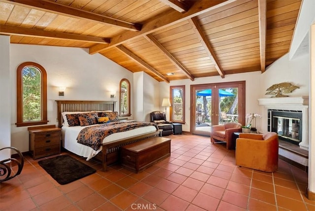 bedroom featuring lofted ceiling with beams, tile patterned flooring, access to exterior, french doors, and a glass covered fireplace