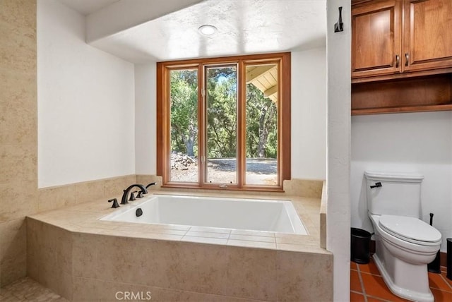 full bathroom with a garden tub, plenty of natural light, toilet, and tile patterned floors