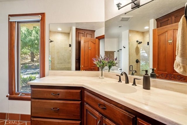 bathroom with a wealth of natural light, visible vents, a shower stall, and vanity