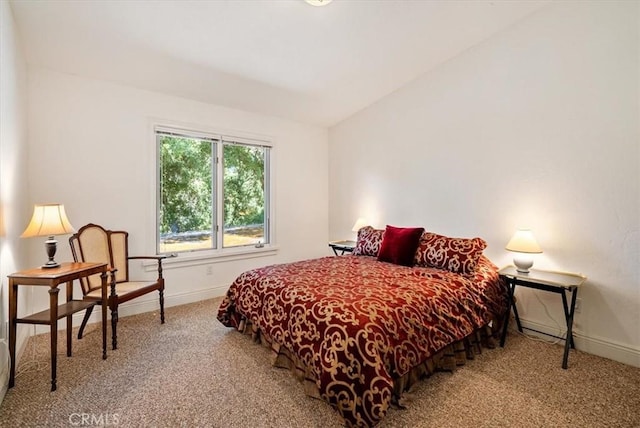 carpeted bedroom with vaulted ceiling and baseboards