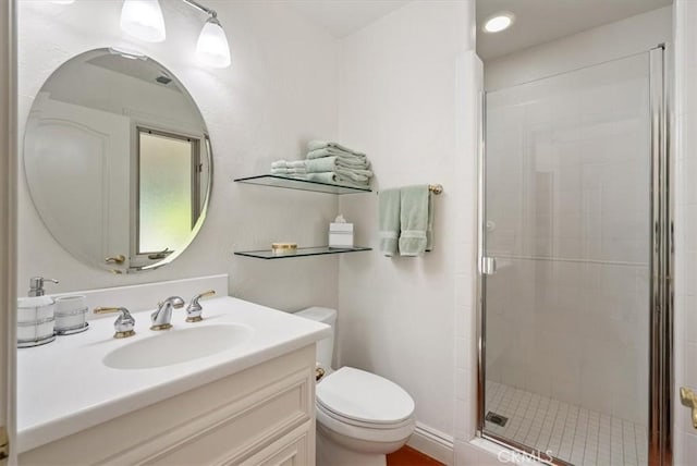 full bath with vanity, a shower stall, and toilet