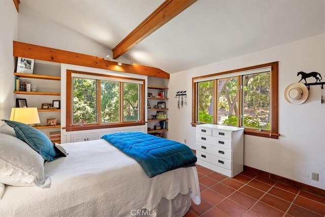 bedroom featuring lofted ceiling with beams, baseboards, and dark tile patterned flooring