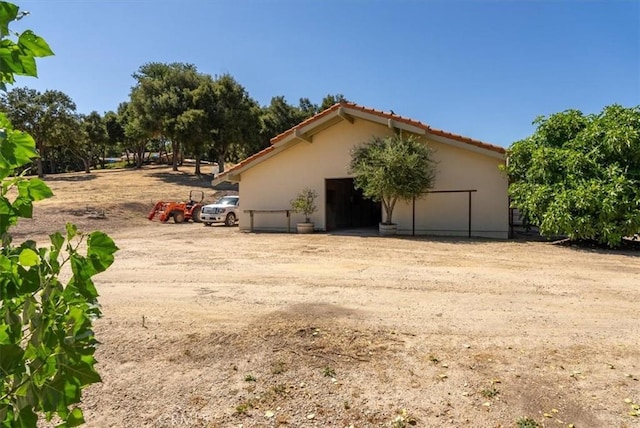 view of side of property featuring an outbuilding, a pole building, and stucco siding