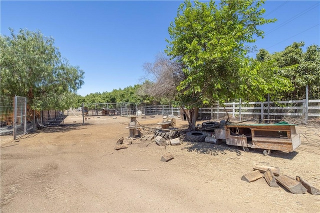 view of yard featuring a rural view, fence, and an outdoor structure