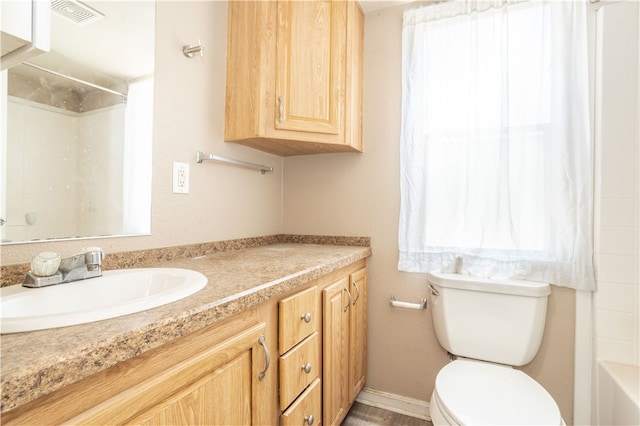 full bathroom with baseboards, visible vents, vanity, and toilet