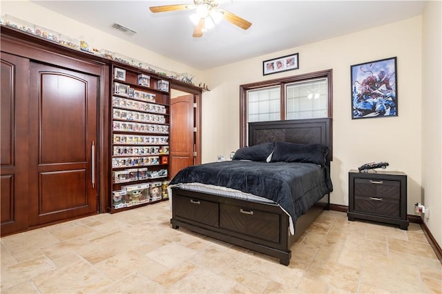 bedroom with a ceiling fan, stone finish floor, visible vents, and baseboards