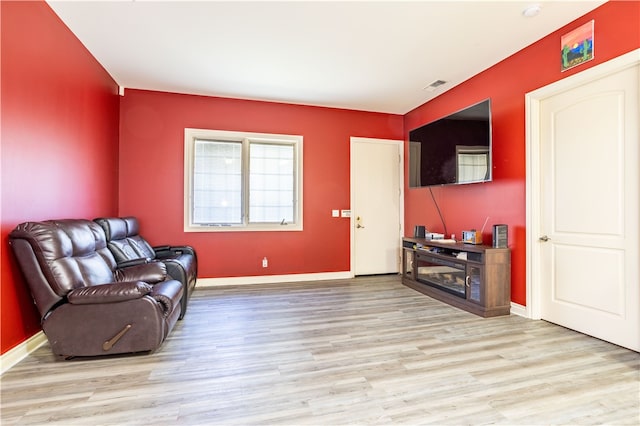 living area featuring light wood-style flooring, visible vents, and baseboards