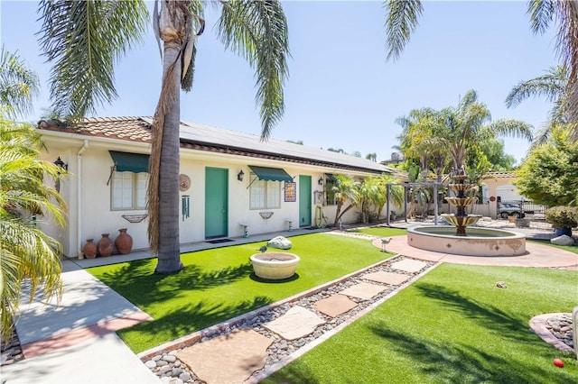 view of front of property with a front yard, a tile roof, and stucco siding