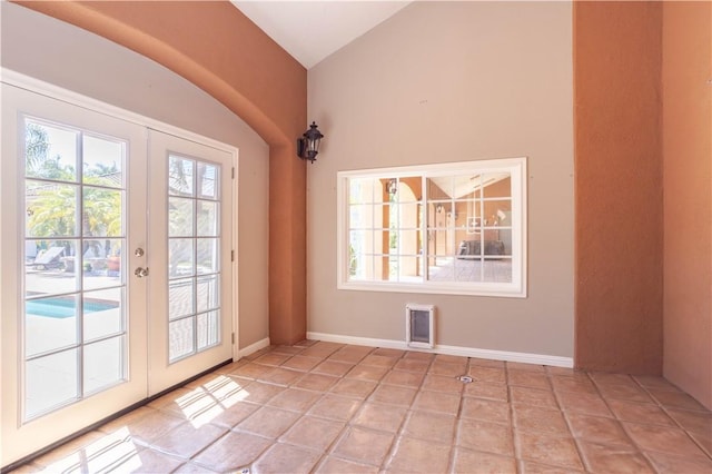 doorway to outside with vaulted ceiling, french doors, plenty of natural light, and light tile patterned floors